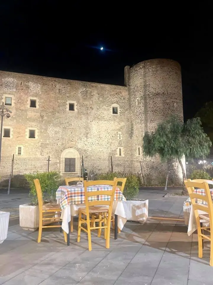 Esterni di Osteria e Pizzeria dai Pazzi, con sullo sfondo il castello Ursino.