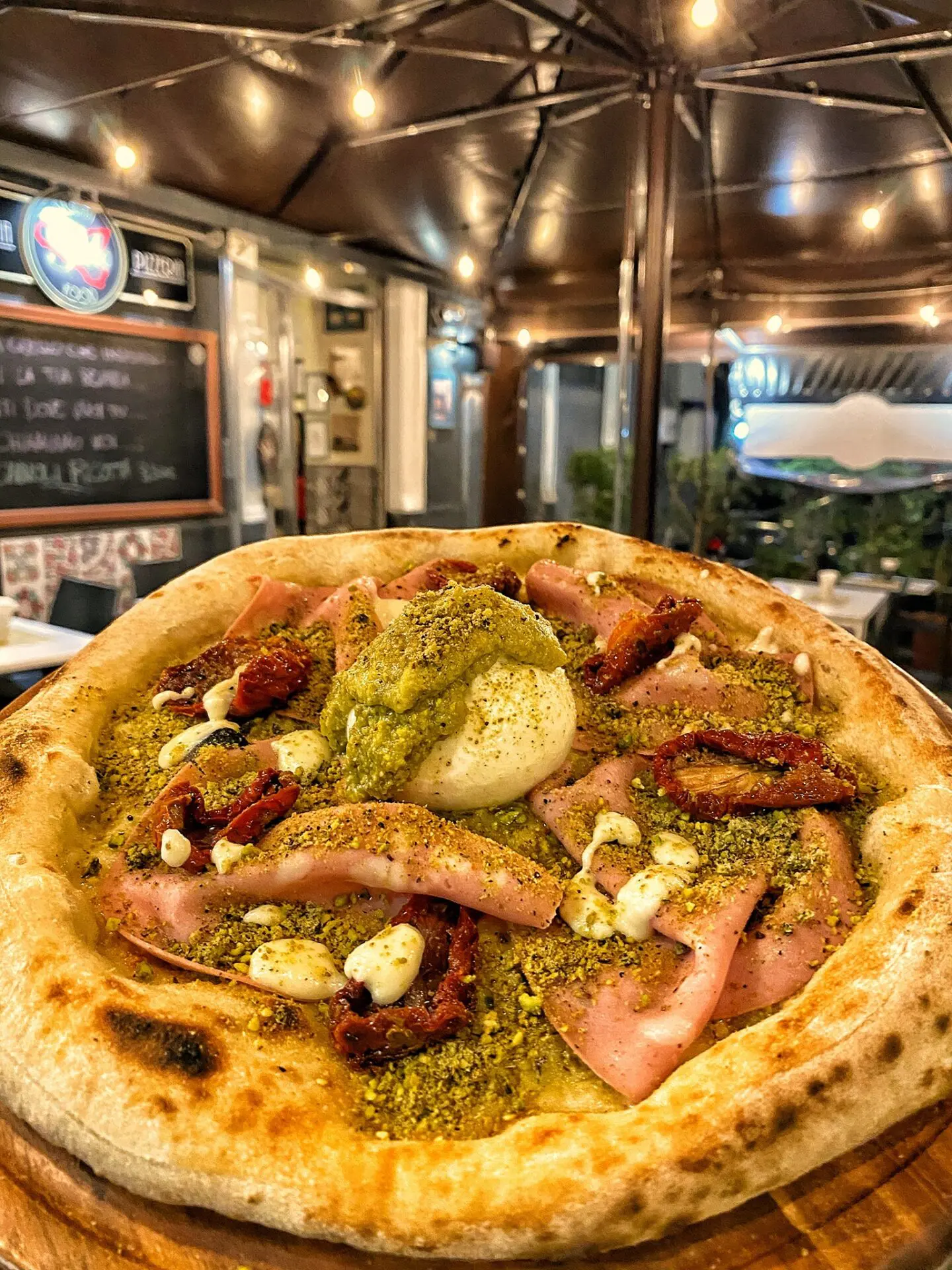 Una golosissima pizza mortadella e pistacchio da Sleto Pizzeria & Hamburger. Pizza in primo piano, pizza ben farcita.