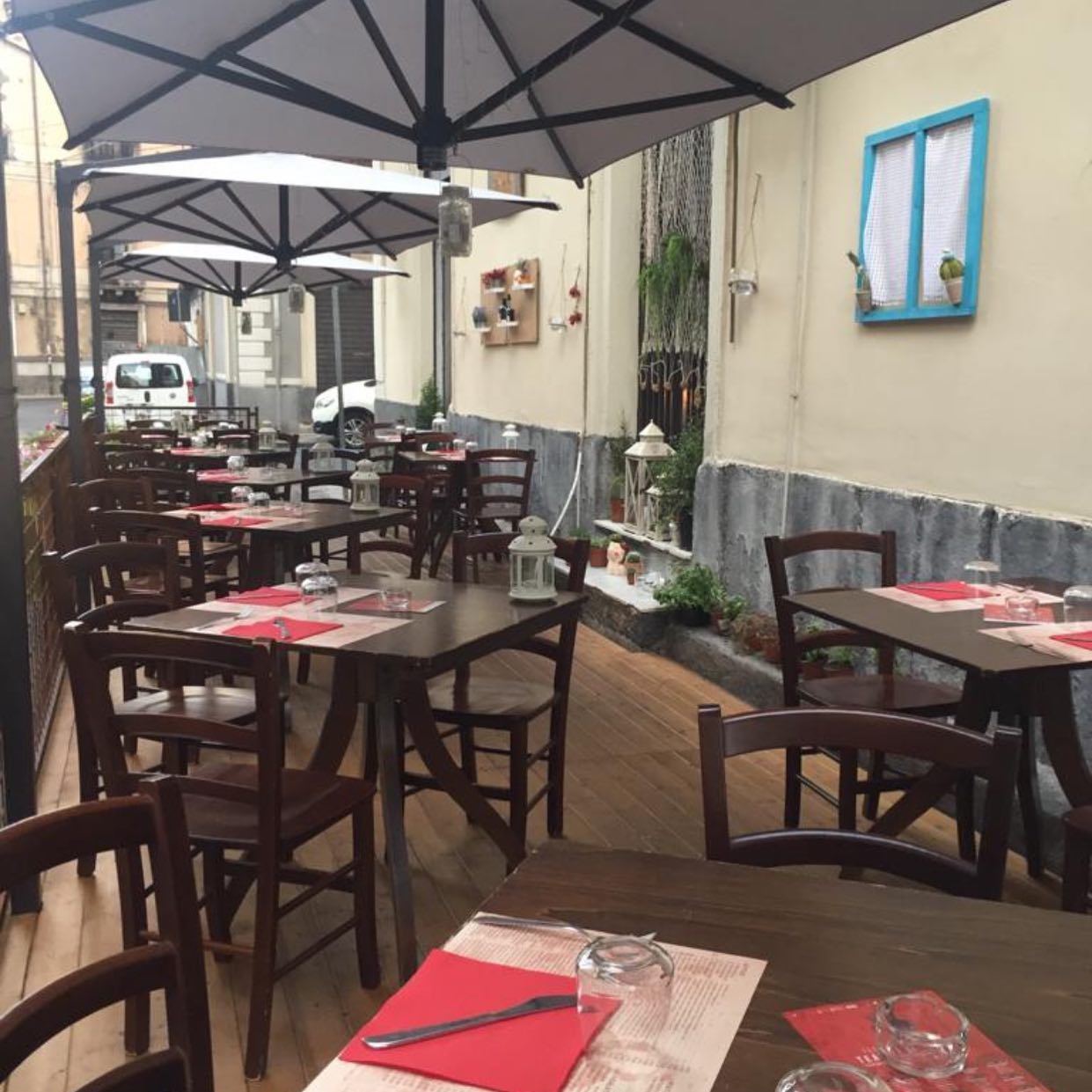 Veranda esterna con ombrelloni di un ristorante, nello specifico della pizzeria I Frati a Catania.