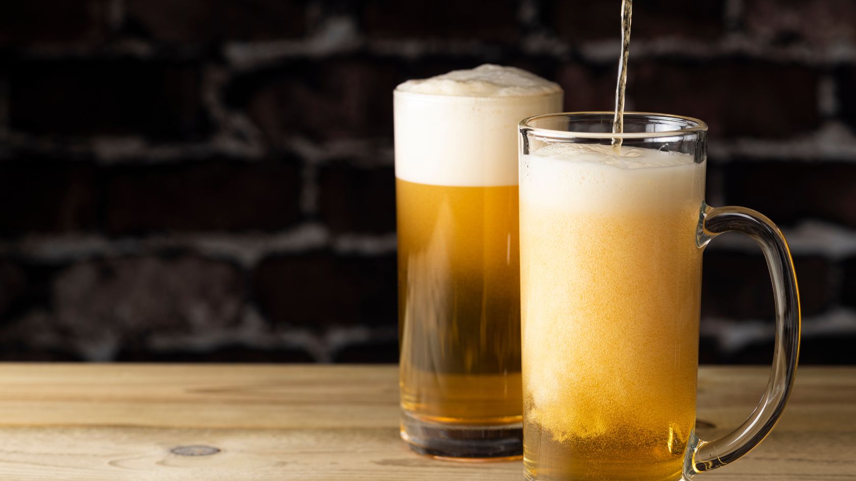 Migliori spillatori birra, birra alla spina, macchina per birra alla spina che versa la birra in due boccali. Birra che viene versata.